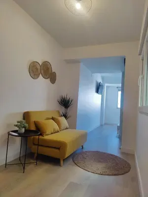 a living room with a yellow couch and a table at O Lar da Muralla in Lugo