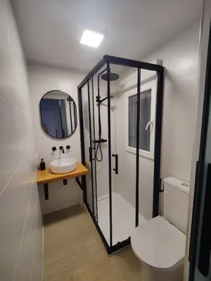 a bathroom with a shower and a sink and a mirror at O Lar da Muralla in Lugo