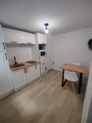 a kitchen with white cabinets and a wooden table at O Lar da Muralla in Lugo