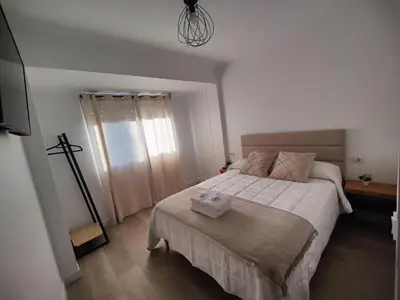 a bedroom with a large bed with white sheets at O Lar da Muralla in Lugo