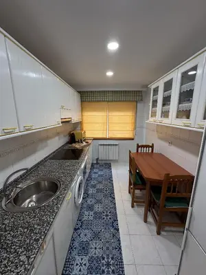 a small kitchen with a sink and a table at Apartamento Villaluz in Monforte de Lemos