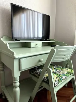a tv on top of a desk with a chair at Apartamento Villaluz in Monforte de Lemos