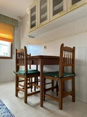a kitchen with a wooden table and two chairs at Apartamento Villaluz in Monforte de Lemos