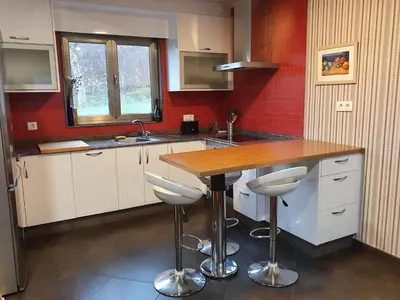 a kitchen with a wooden counter and white cabinets at O pallar in Bardaos