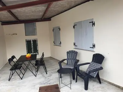 a room with chairs and a table and a table and cabinets at O pallar in Bardaos