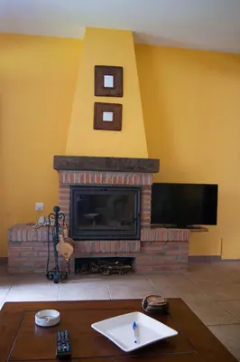 a living room with a fireplace and a flat screen tv at Apartamentos Rurales Casa Marcelo in Veigas