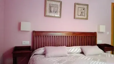 a bedroom with a bed with two pillows on it at Apartamentos Rurales Casa Marcelo in Veigas