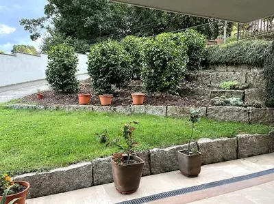a garden with potted plants and a stone wall at La casita del bosque in Lugo