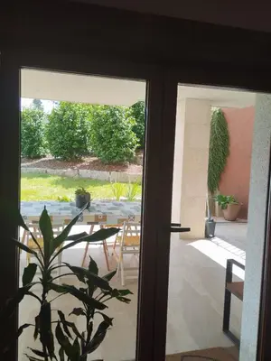 a door leading to a patio with a table and chairs at La casita del bosque in Lugo