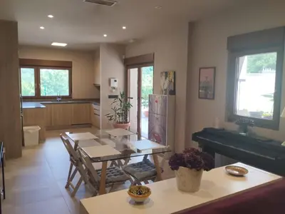 a living room with a table and a piano at La casita del bosque in Lugo