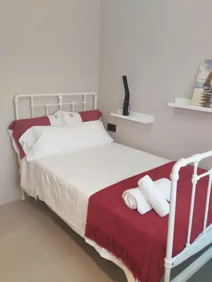 a bedroom with a white bed with two towels at La casita del bosque in Lugo