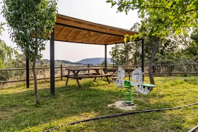 a picnic shelter with a picnic table and a bench at Casa de turismo rural Sardom2 in Bembibre
