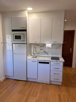 a kitchen with white appliances and white cabinets at Las candelas in Astorga