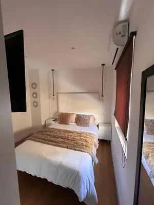 a small bedroom with two beds and a television at Las candelas in Astorga