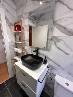 a bathroom with a black sink and a marble wall at Las candelas in Astorga