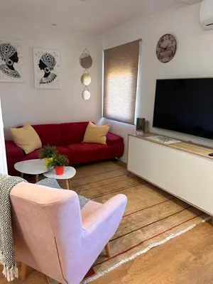 a living room with a red couch and a flat screen tv at Las candelas in Astorga