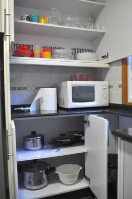 a kitchen with a microwave and some dishes on shelves at Curros Enríquez RD, Céntrico, PLAZA GARAGE in Ourense