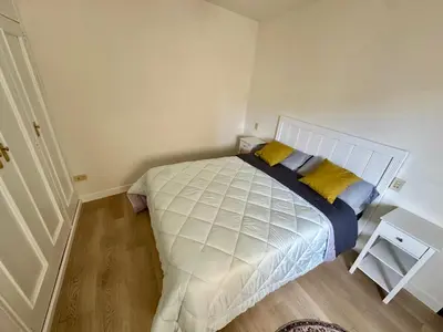 a bedroom with a large white bed with yellow pillows at Apartamento DENTRO DE MURALLA y PARKING GRATUITO en pleno centro in Lugo