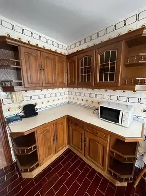 a kitchen with wooden cabinets and a microwave at Apartamento DENTRO DE MURALLA y PARKING GRATUITO en pleno centro in Lugo