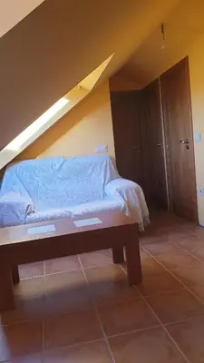 a bedroom with a bed and a wooden table at Buhardilla Cesar in Lubián