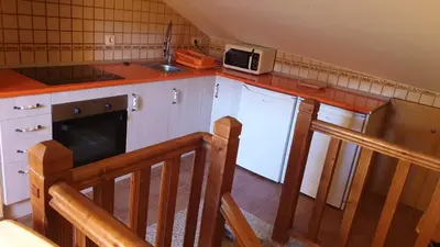 a kitchen with a sink and a microwave on a counter at Buhardilla Cesar in Lubián