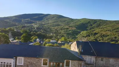 a group of houses with mountains in the background at Buhardilla Cesar in Lubián