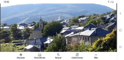 a town with a church and a mountain in the background at Buhardilla Cesar in Lubián