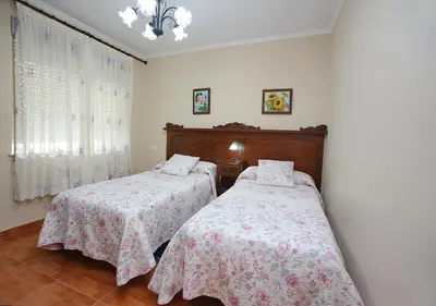 a bedroom with two beds and a window at Pensión Casa Elena in Reinante
