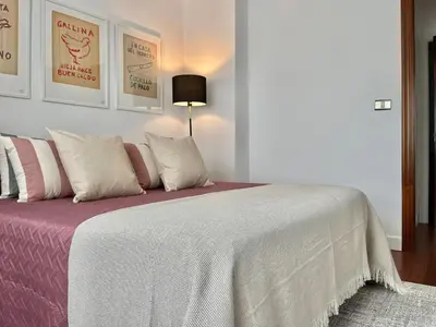 a bedroom with a bed with a white blanket and pillows at Nuevo Piso en Couto in Ourense