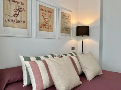 a bedroom with a couch with pillows and posters on the wall at Nuevo Piso en Couto in Ourense