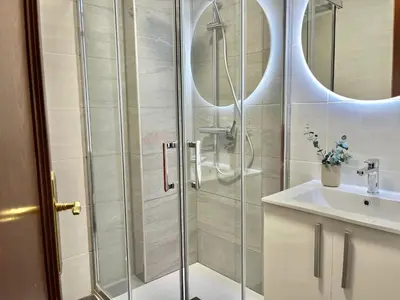 a shower with a glass door next to a sink at Nuevo Piso en Couto in Ourense