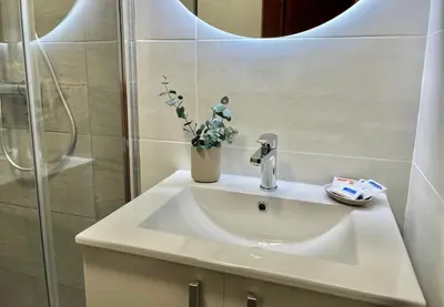 a bathroom sink with a vase of flowers on it at Nuevo Piso en Couto in Ourense