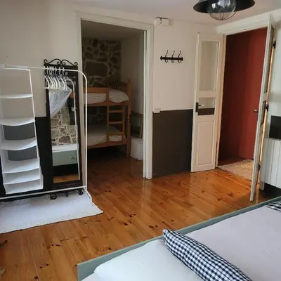a room with a bed and a room with a wooden floor at El Abuelo Angel in Ribadavia