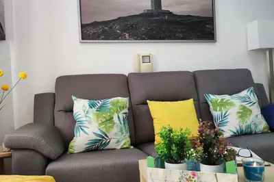 a living room with a gray couch with colorful pillows at Fogar do Vento-Ordes, cerca de Camino Inglés Bruma in Ordes