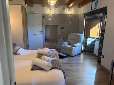 a room with two beds and a couch and a chair at 27A01 Casa Uría Cam Santiago by R2R Consulting in Berducedo