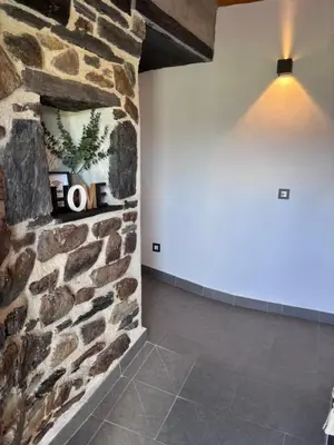 a room with a stone wall and a light at 27A01 Casa Uría Cam Santiago by R2R Consulting in Berducedo