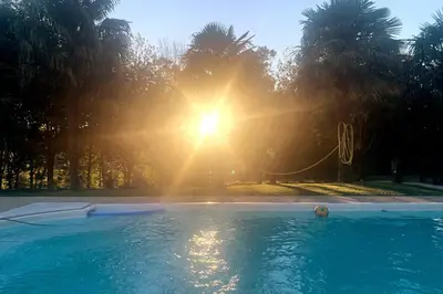a swimming pool with the sun in the background at A chousa da folgueira in Ordes
