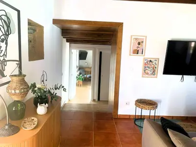 a living room with a couch and a tv on a wall at A chousa da folgueira in Ordes