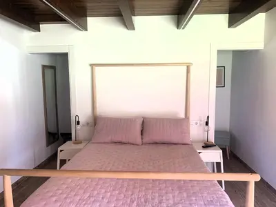 a bedroom with a large bed with pink sheets at A chousa da folgueira in Ordes