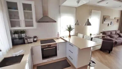 a kitchen and living room with a couch and a television at Casa en Cortiñan in Bergondo