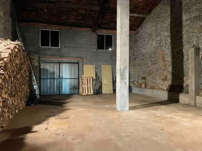 a large room with a door and a stone wall at Casa da Baltasara in Trives