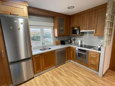 a kitchen with wooden cabinets and a stainless steel refrigerator at Casa da Baltasara in Trives