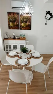 a white dining room with a table and chairs at casa Chloe in Ourense