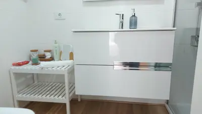 a white bathroom with a sink and a shelf at casa Chloe in Ourense