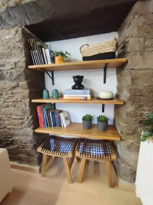 a room with a wooden table and shelves with books at La Escondida VuT-LE-952 in Caboalles de Abajo