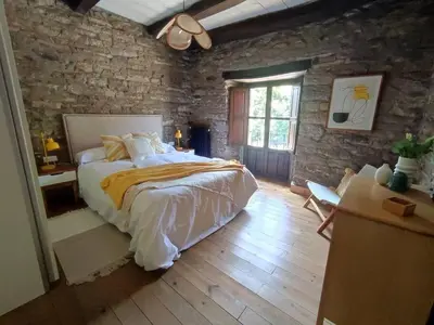 a bedroom with a large bed and a brick wall at La Escondida VuT-LE-952 in Caboalles de Abajo