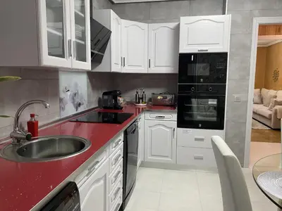 a kitchen with white cabinets and a red counter top at Army Deluxe in Astorga