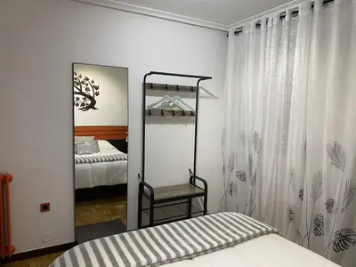 a mirror in a bedroom with a bed and a chair at Army Deluxe in Astorga