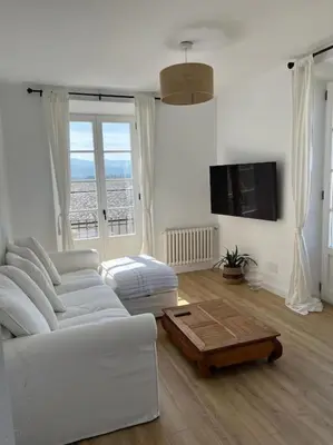 a living room with a white couch and a coffee table at Apartamento en plaza de Ribadeo in Ribadeo