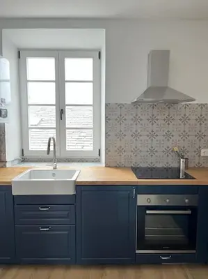 a kitchen with blue cabinets and a sink at Apartamento en plaza de Ribadeo in Ribadeo